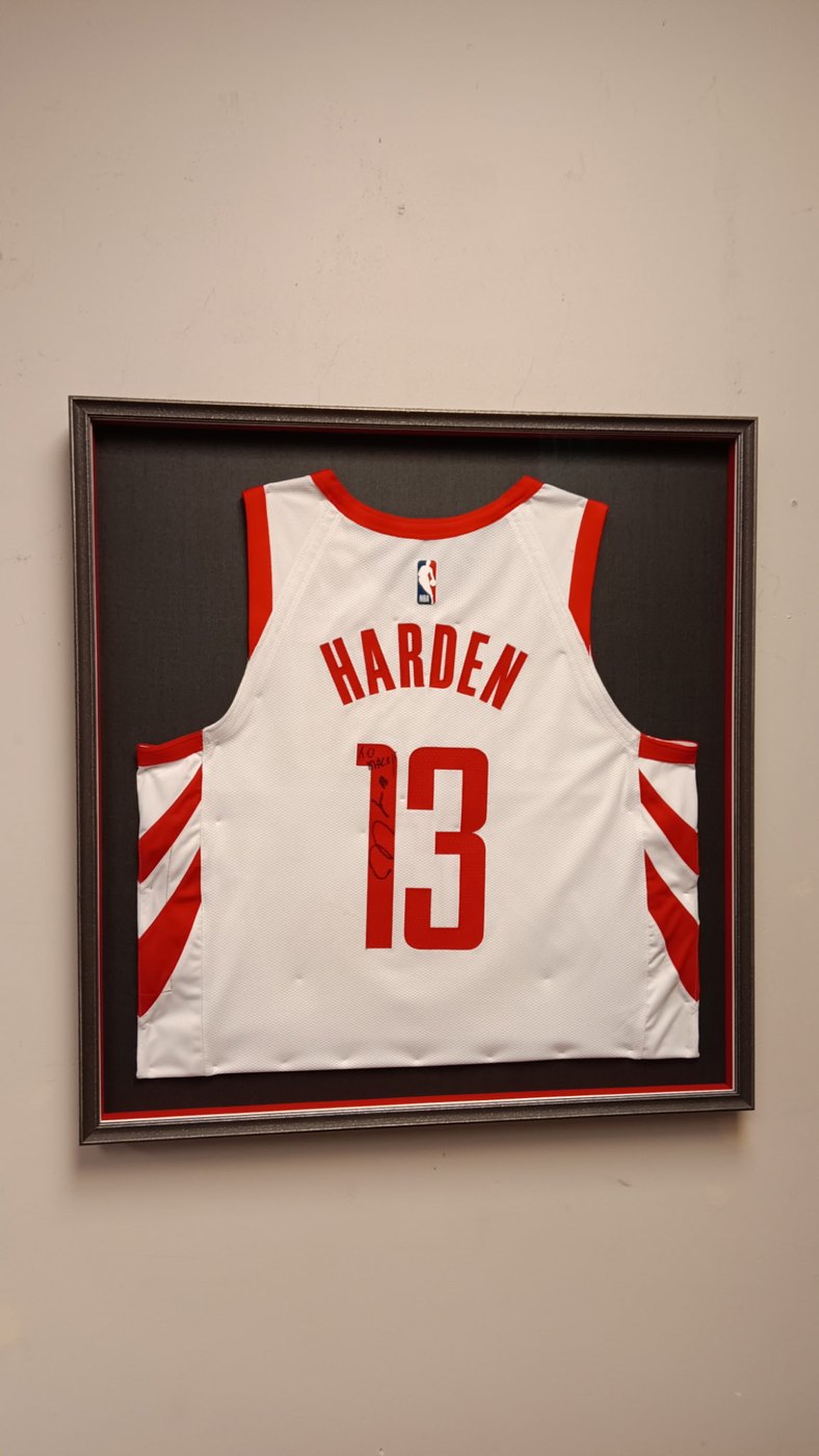 A signed Harden #13 basketball jersey framed with a black mat